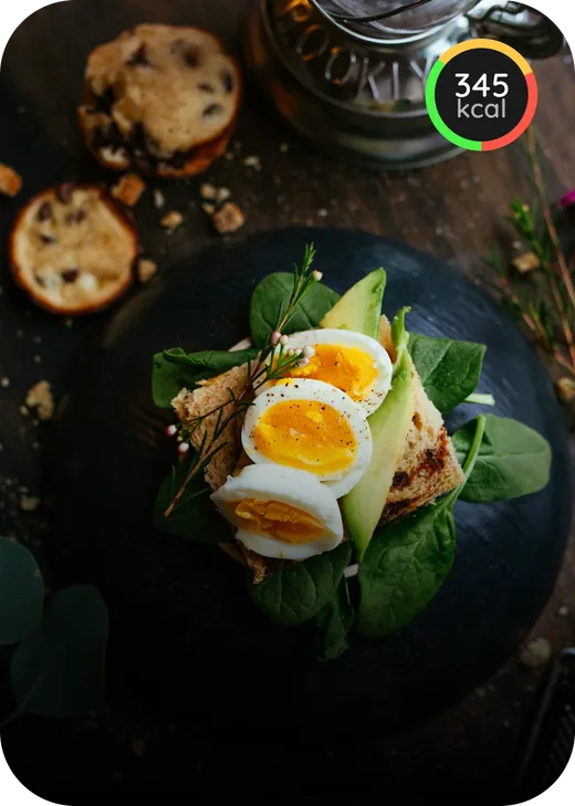 Toast topped with avocado, spinach, and sliced eggs